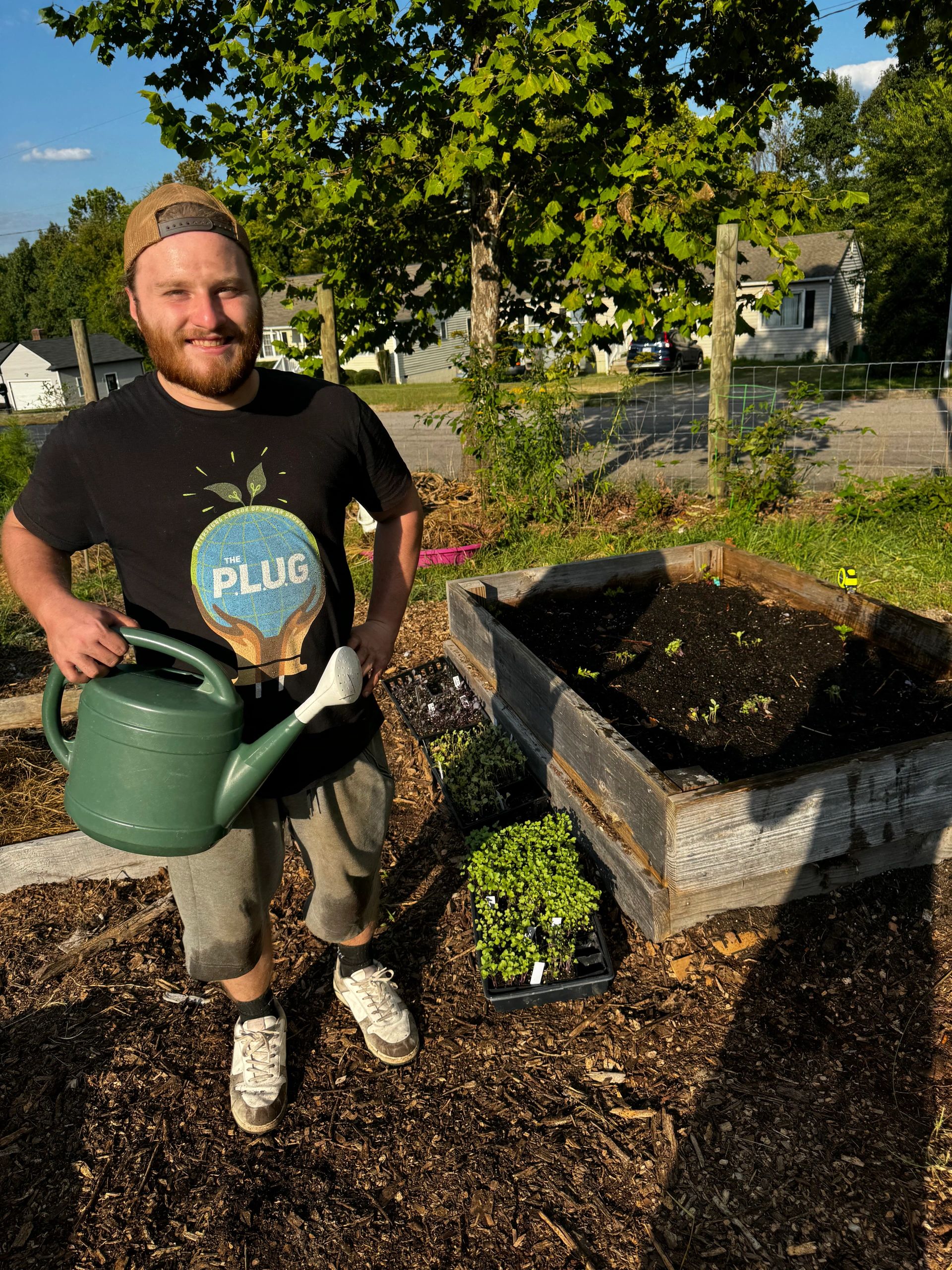 Youth Farm Assistant & Young Pharaoh, James Light, watering the Happily Natural Outdoor Learning Lab at the Petersburg Oasis Youth Farm