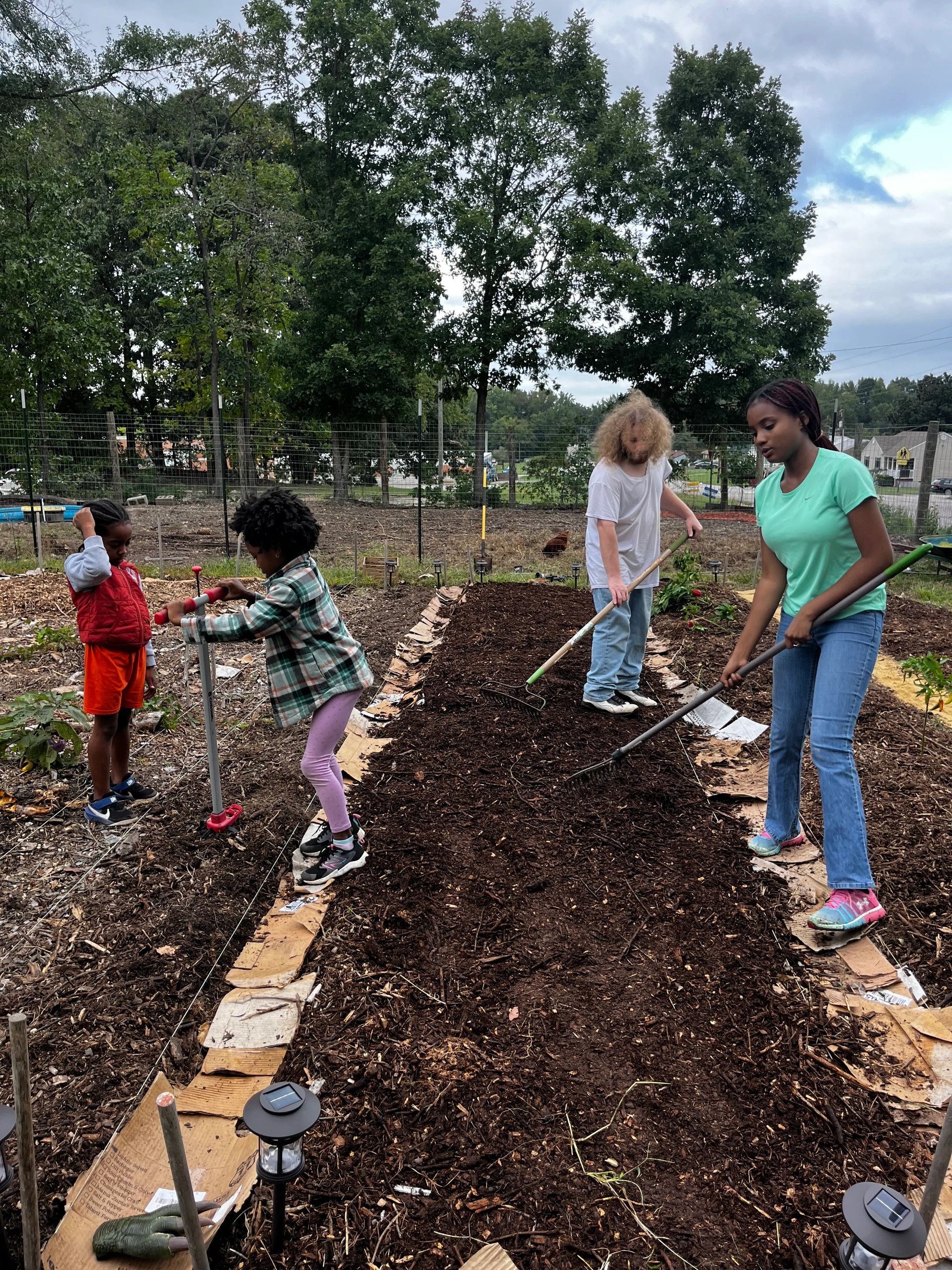 Local youth cultivating garden beds in Papa Kelley’s Vegetable Garden at the Petersburg Oasis Youth Farm
