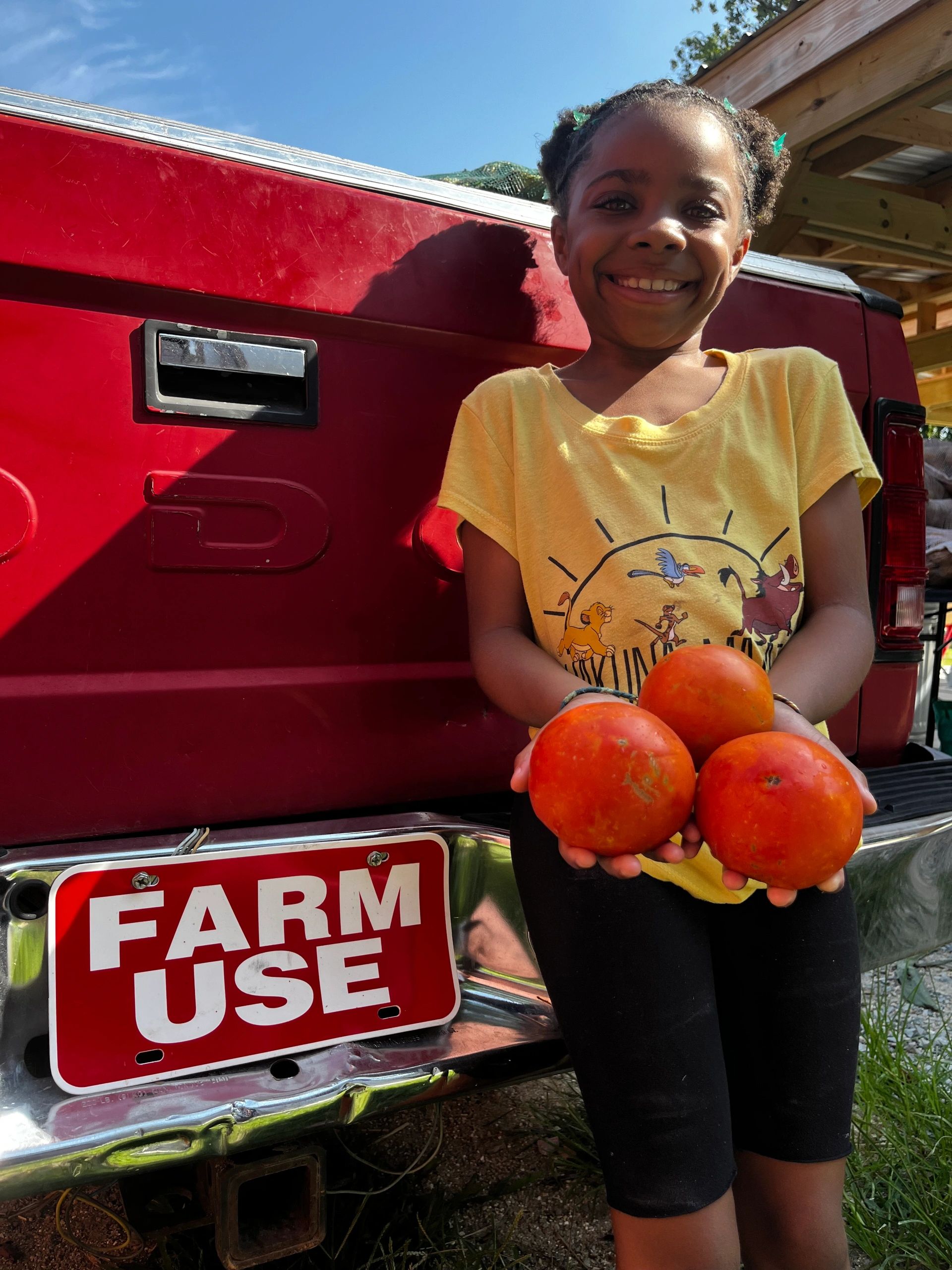 Youth Farm Manager & Mobile Market Assistant, Jade(11), showing off some beautiful locally grown tomatoes 